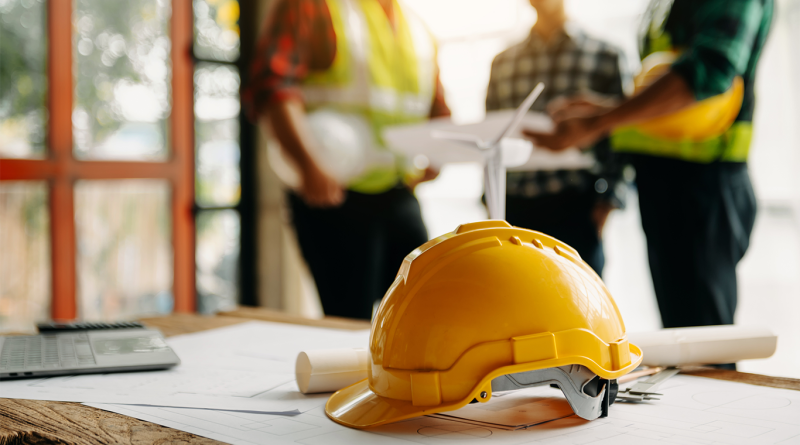 The Community-First Model of IUPAT DC6’s Training Programs hardhat on table at work site with construction training happening